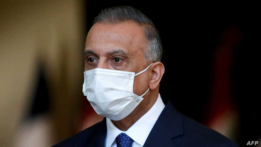 Iraq's Prime Minister Mustafa al-Kadhemi, mask-clad due to the COVID-19 coronavirus pandemic, looks on during a joint press…