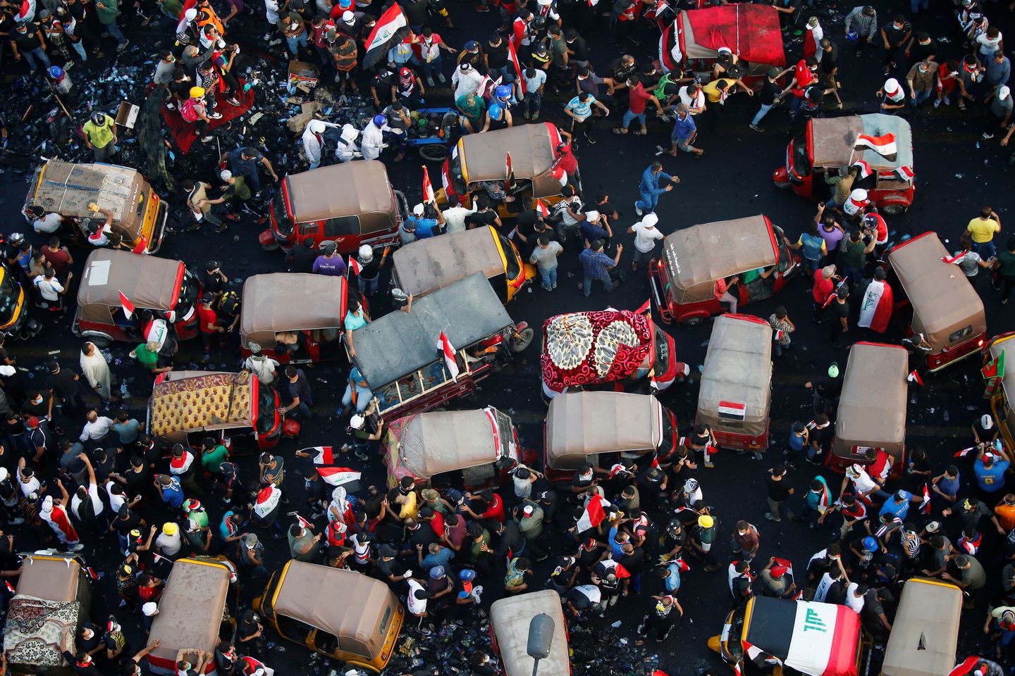 Demonstrators and tuk-tuk drivers take part in anti-government protests in Baghdad on Wednesday. (Thaier Al-Sudani/Reuters)